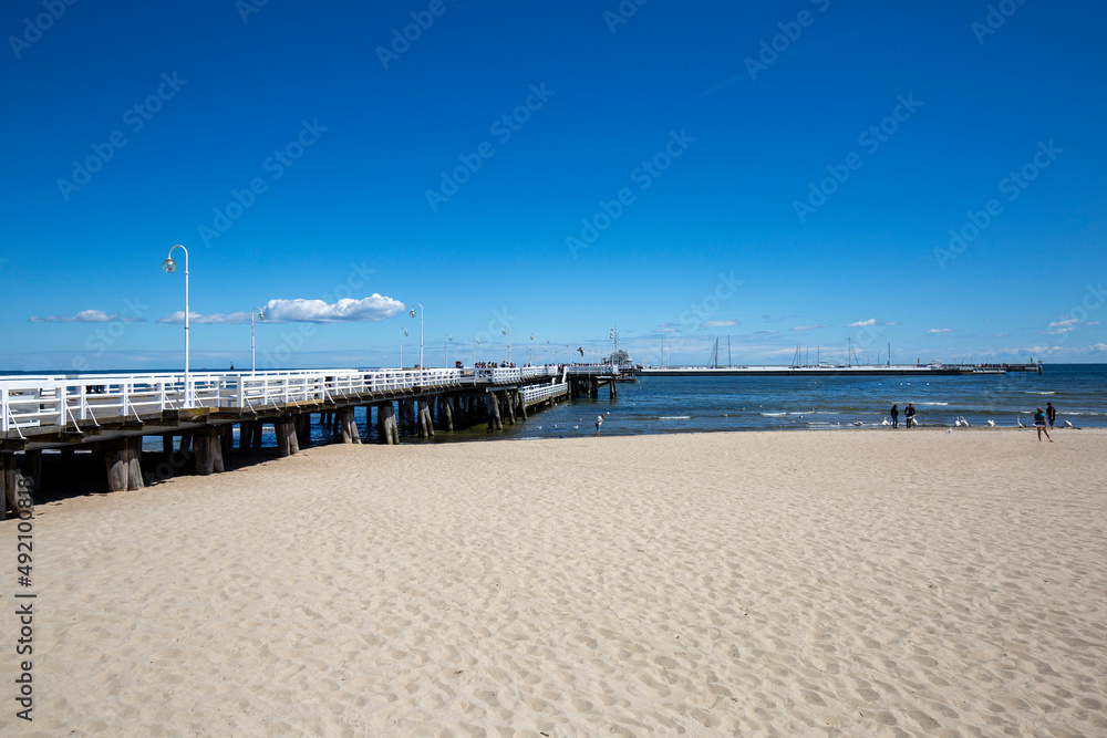 Wooden Sopot pier in sunny day, view from the sandy beach, Sopot, Poland