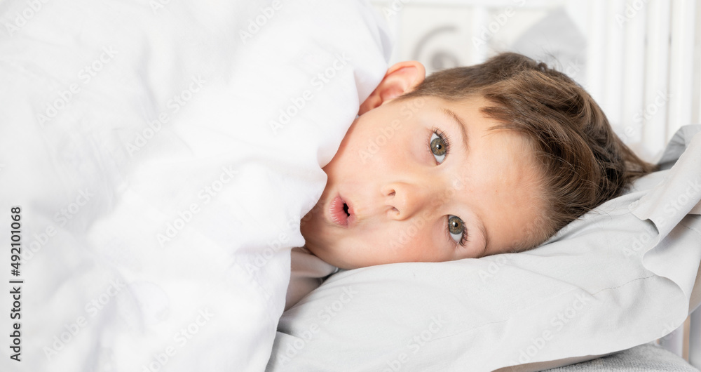 Portrait of playful little boy in bed. Daily regime concept Portrait of playful little boy in bed. Daily regime concept