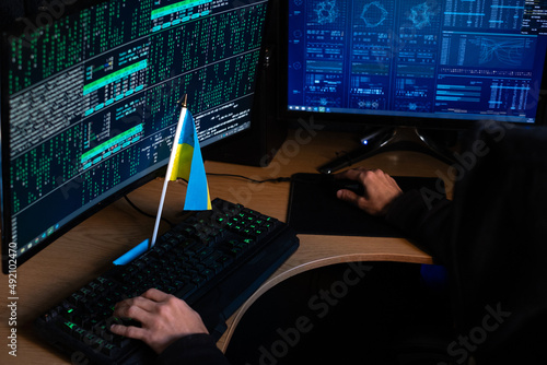 a man at a computer with a Ukrainian flag. The concept of supporting Ukraine with the help of the Internet