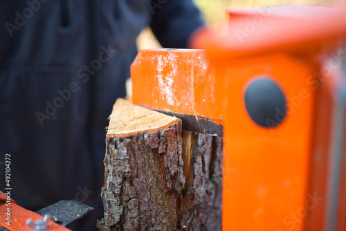 Obraz na plátně Close-up shot of a hydraulic wood splitter cutting fire wood on a sunny day