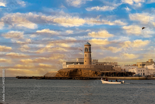 A picture of a lighthouse on the coasts of the city of Tyre in Oman, the beauty of nature in Oman, the buildings and ports at the northern end of the coasts of Tyre, tourist places