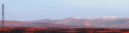 Sierra de Guadarrama vista desde el norte de la ciudad de Madrid al amanecer. Los picos de las montañas nevados en invierno y con el color rosado de los primeros rayos del amanecer.