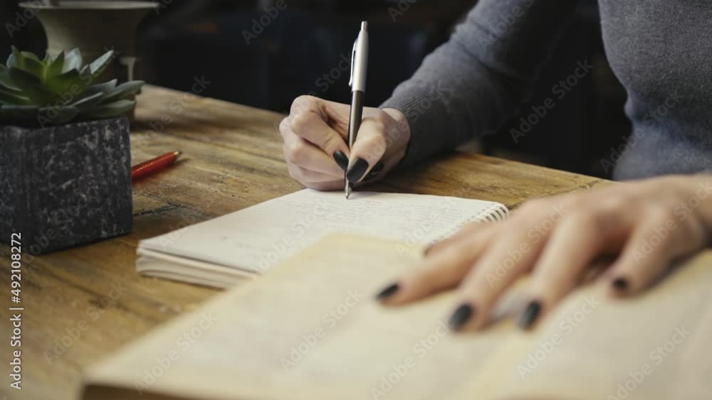 Close up of hand as writing notes. Woman working, learning, writing at desk Close up of hand as writing notes. Woman working, learning, writing at desk