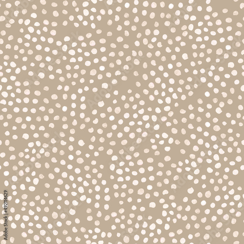 Seamless stylish minimalistic pattern on a beige background with textured polka dots in light shades. For textiles, wallpaper, wrapping paper, children's clothing, postcards, website design.