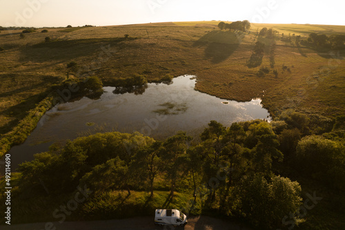 Campervan parked in the woods next to a lake