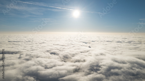 plane window view of midday sun and clouds