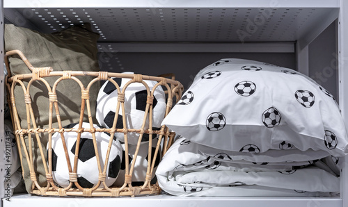Bedding with football print. Soft toy soccer balls in a wicker basket.