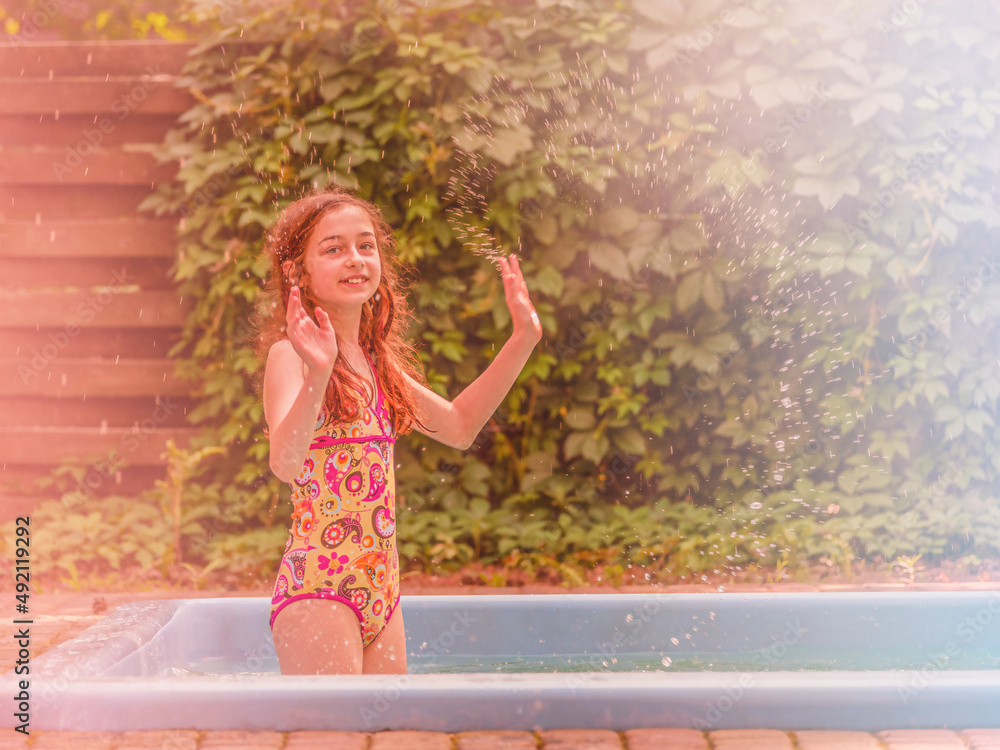 Happy vacation. The girl in a bathing suit enjoys a summer vacation by the pool.