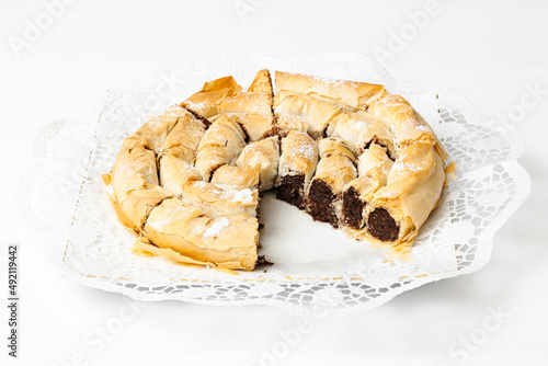 Cut date roll cake on a plate on white background