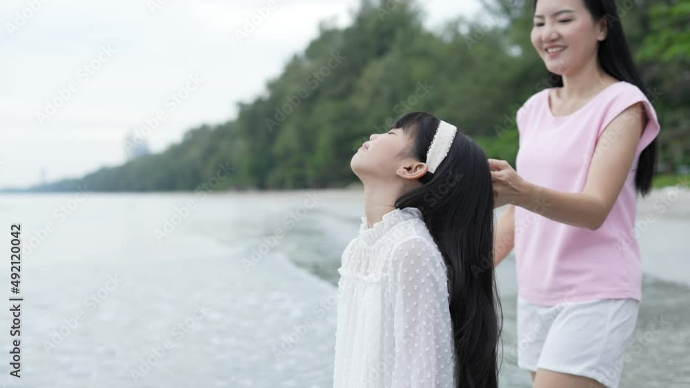 Holiday concept of 4k Resolution. Mother and daughter looking at the view on the beach. Holidays for Asian family travelers. Holiday concept of 4k Resolution. Mother and daughter looking at the view on the beach. Holidays for Asian family travelers.