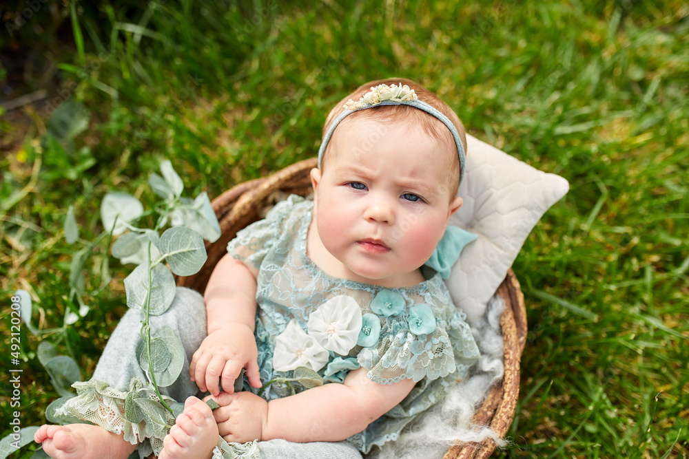 Cute little girl in a beautiful flowering shrub in the park in summer