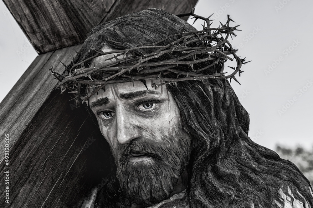 Fototapeta premium The statue of Jesus Christ with a cross and a thorn wreath on the head (religion, Christianity, faith concept)