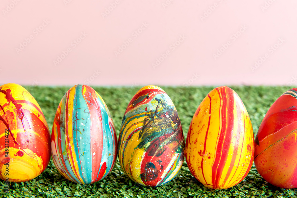 Decoration with colored easter eggs on grass background.
