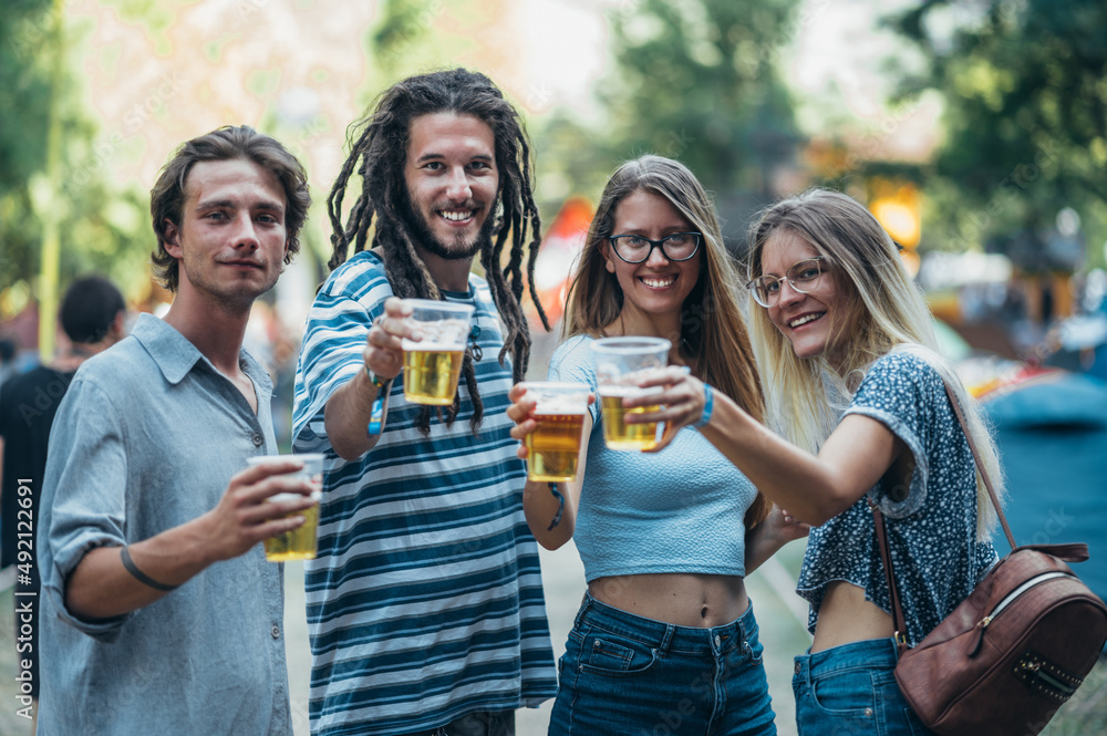 Obraz premium Friends drinking beer and having fun at music festival