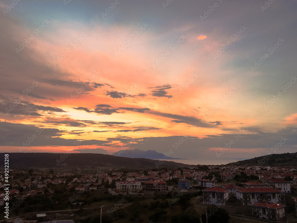 Fototapeta premium a seaside town between two mountains wit sea gull flight or an island in the Aegean, Gokceada, Imbros, turkey, clouds, sky 