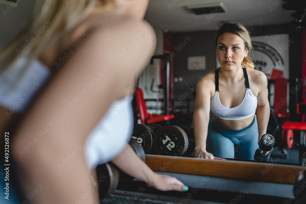 One woman training at the gym using dumbbell for back exercise health and fitness female workout concept real people copy space One woman training at the gym using dumbbell for back exercise health and fitness female workout concept real people copy space
