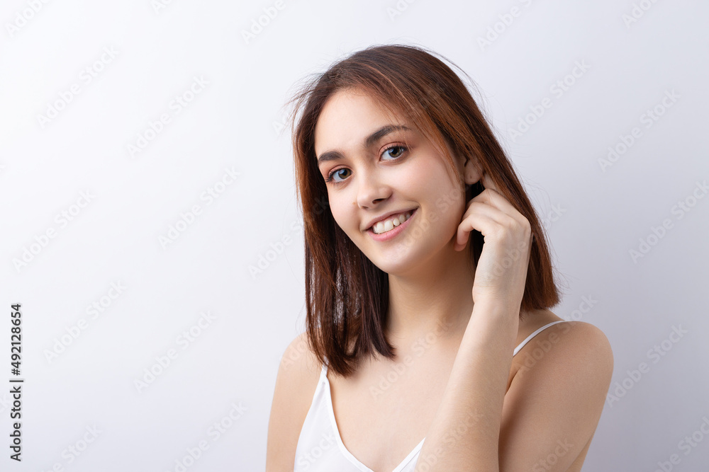 Beautiful smiling woman with clean skin, natural make-up and white teeth on a gray background Beautiful smiling woman with clean skin, natural make-up and white teeth on a gray background