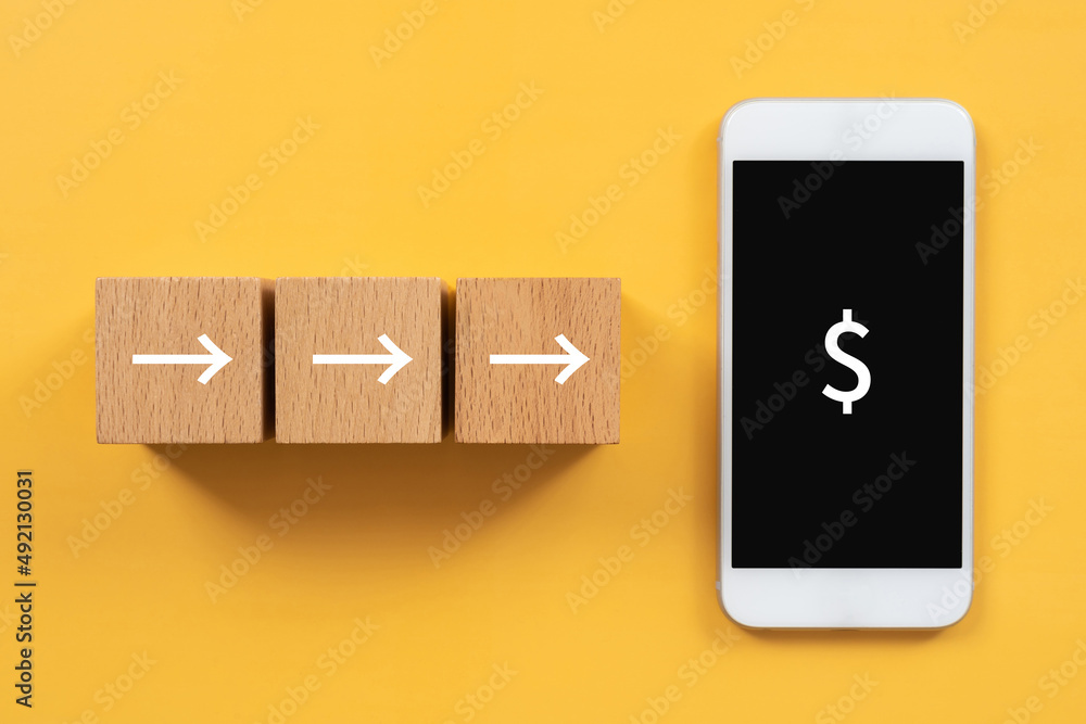 入金のイメージ 矢印マークの積み木とドルマークが表示されているスマートフォン Stock Photo Adobe Stock