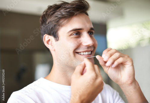 He knows the importance of dental hygiene. Closeup of a young man flossing.