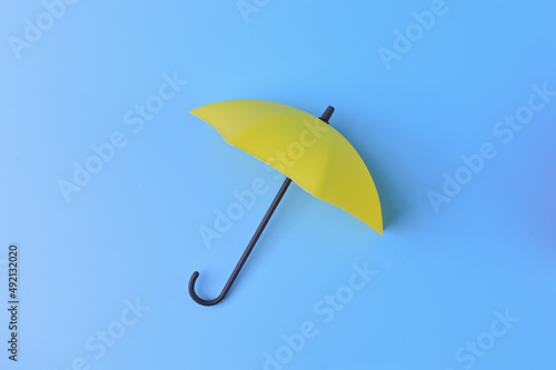 Yellow toy umbrella isolated on a blue background