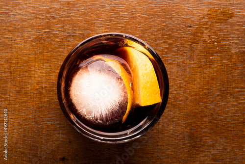 Negroni drink with round ice top view on wooden table