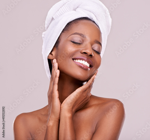 Love the skin youre in. An isolated studio shot of a beautiful young woman wearing a towel on her head.