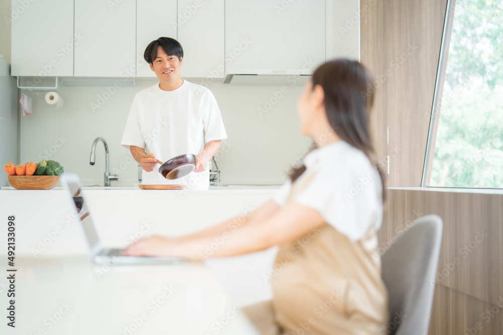 テレワークする妊婦と家事をする男性
テレワークする妊婦と家事をする男性