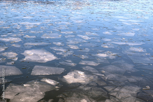 Broken ice floes floating on the river in spring day perspective view