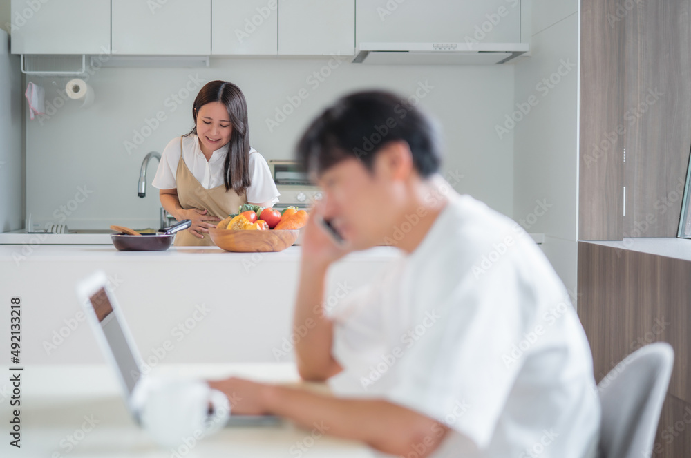 出産直前の妊婦と仕事する男性（体調不良）
