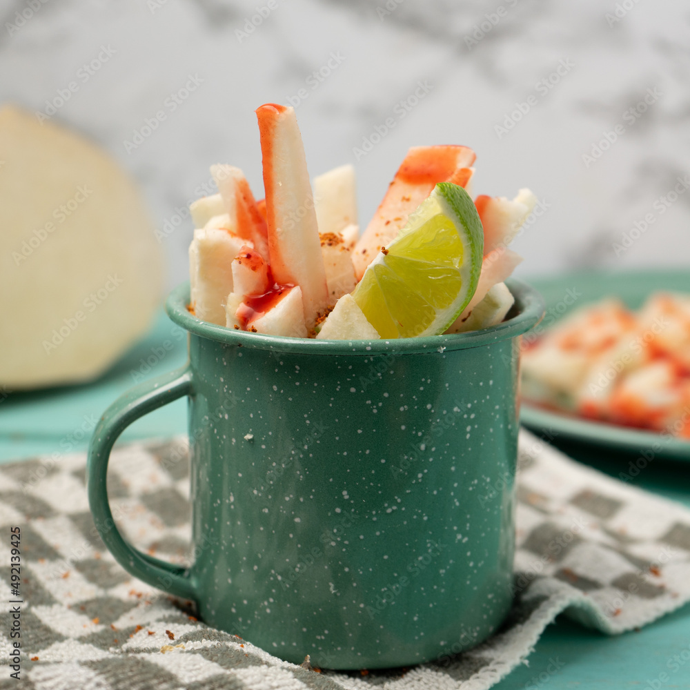 Mexican yam bean also called Jicama with chili powder and chamoy sauce