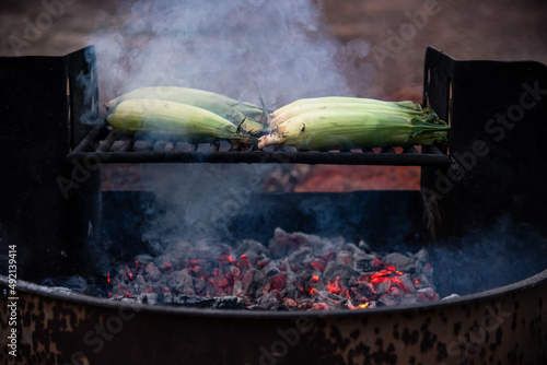 Roasting corn over coals 
