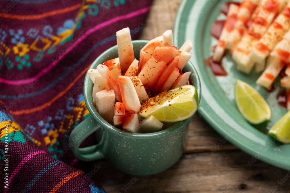 Mexican yam bean also called Jicama with chili powder and chamoy sauce