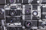 Old retro cameras lie in rows to each other