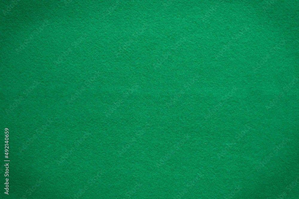 Poker table felt background in green color. There is a black vignette at the corner of the image. close up, texture, copy space, rummy Poker table felt background in green color. There is a black vignette at the corner of the image. close up, texture, copy space, rummy
