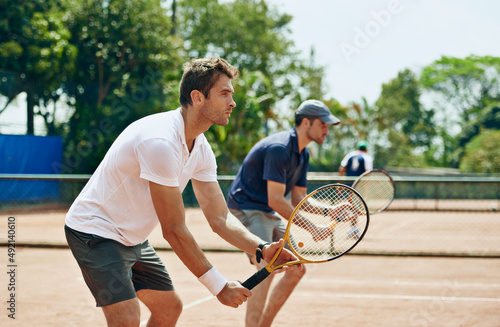 Double trouble. Shot of two tennis players on the.same team waiting for the ball. © Marius V/peopleimages.com