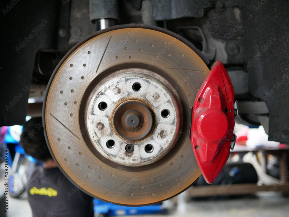 maintaining car wheel brake disc at repair service station.