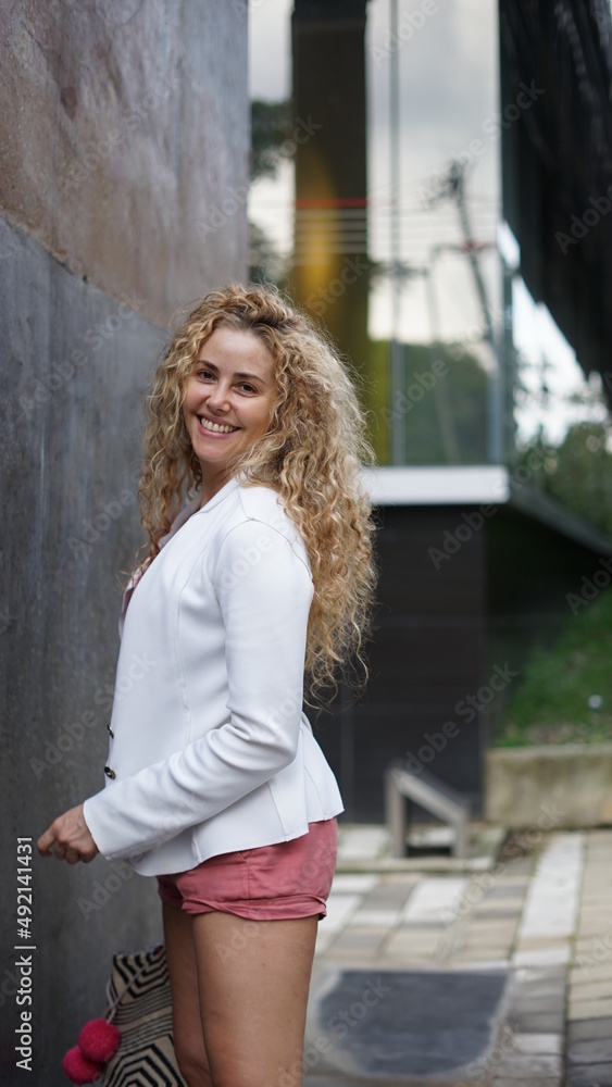 Smiling and happy businesswoman standing in a business park Smiling and happy businesswoman standing in a business park