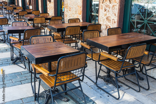 Atmospheric summer photography. Wooden cafe chairs  and  tables. Outdoor street cafe