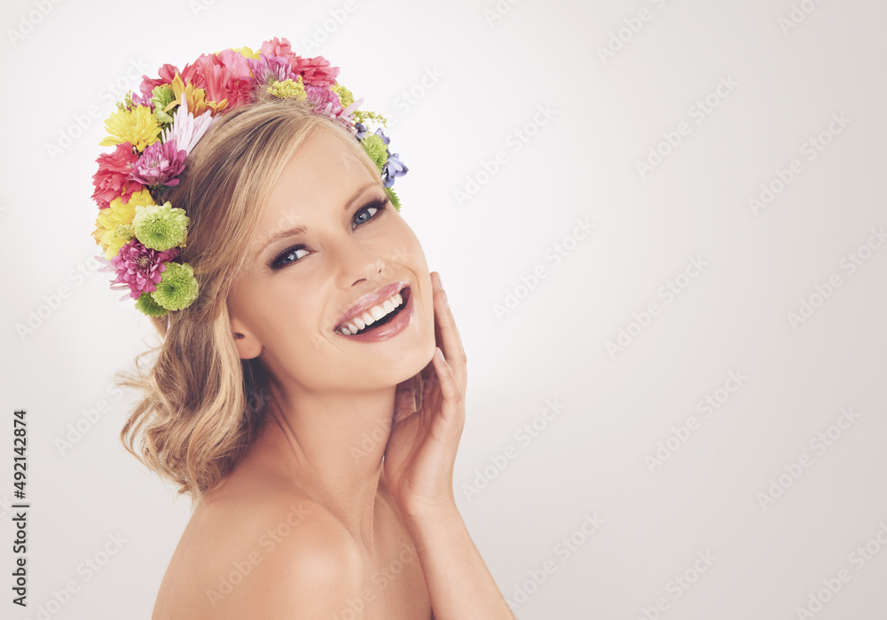 Wearing the only crown fit for a spring goddess. A young woman with a flower arrangement in her hair smiling at the camera. Wearing the only crown fit for a spring goddess. A young woman with a flower arrangement in her hair smiling at the camera.