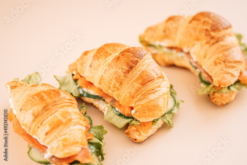 Sandwiches with red fish and salad on light background.