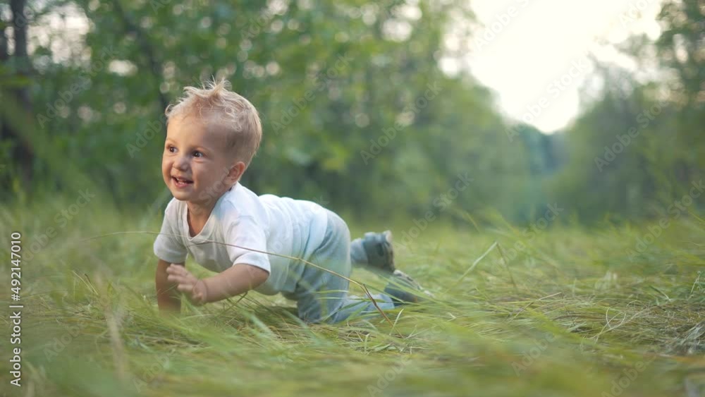 little baby boy crawling a on the grass in the park. happy family kid dream concept. little boy baby crawling outdoors in the park playing. happy family fun childhood concept little baby boy crawling a on the grass in the park. happy family kid dream concept. little boy baby crawling outdoors in the park playing. happy family fun childhood concept