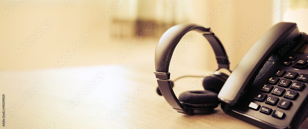 Customer service concept. Close-up headphone and telephone for communication helpdesk IT support or call center and online services. Customer service concept. Close-up headphone and telephone for communication helpdesk IT support or call center and online services.