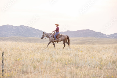 Cowgirl riding grey horse