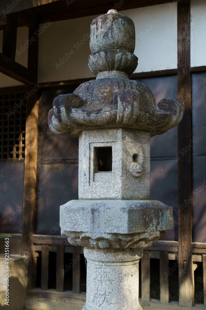 神社の境内に灯をともす石の灯篭