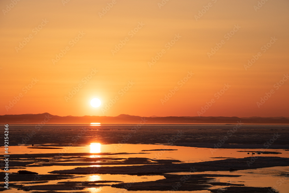 Fototapeta premium 氷が浮かぶ夕暮れの光る湖