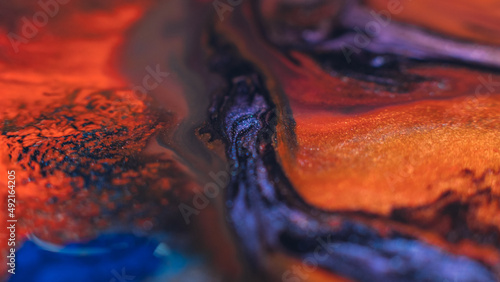 Ink blend. Artistic hobby. Colorful abstract bakgrund. Purple violet orange paints mix