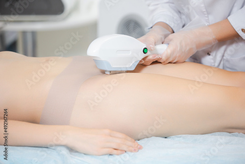 Close up shot of a girl on a cosmetology chair during the procedure of laser hair removal of the bikinia zone