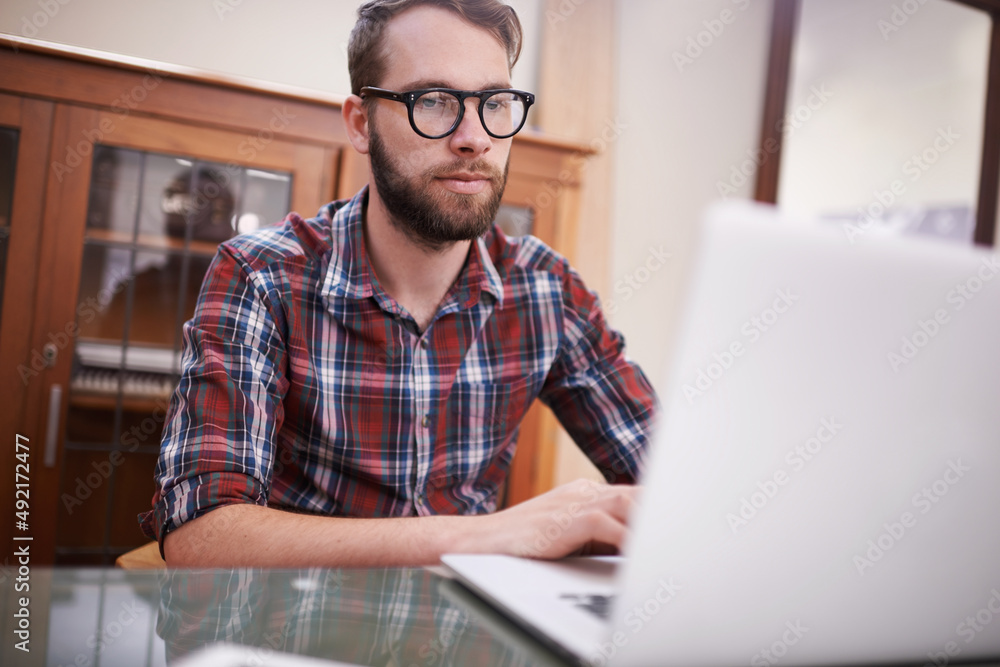 Using all the latest tech. Shot of a handsome young hipster working on a laptop. Using all the latest tech. Shot of a handsome young hipster working on a laptop.