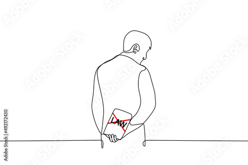 man stands hiding behind his back book with cover of the crossed out word "LAW" - one line drawing vector. concept of violating law, breaking law, disregarding law