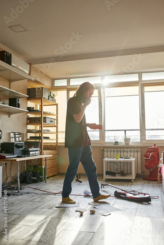 Side view of young man with notebook going at home